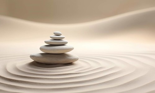 Zen stones stack on raked sand in a minimalist setting for balance and harmony. Balance, harmony,