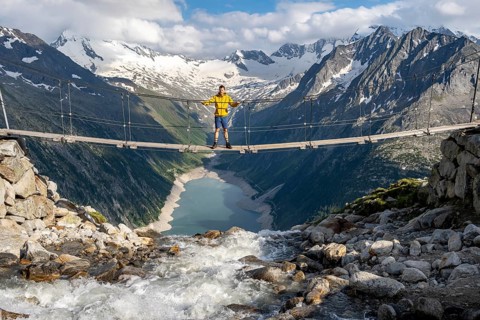 Mountaineers on a suspension bridge over a mountain stream Alelebach, picturesque mountain