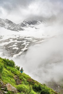 Mountaineers on a hiking trail, Schlegeiskees glacier in the background, cloudy and atmospheric