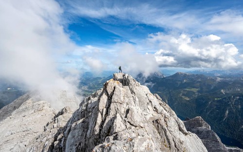 Mountaineer on the rocky summit of the Watzmann Mittelspitze, Watzmann crossing, view of mountain