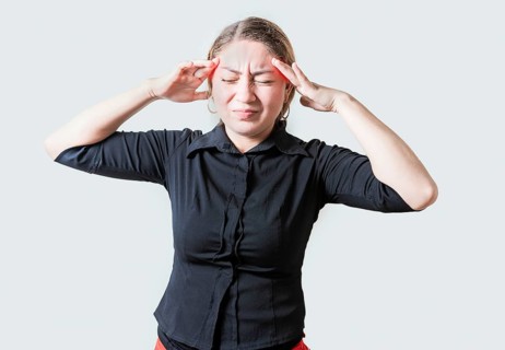 Young woman with headache isolated. Portrait of girl suffering from migraine on isolated background