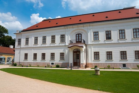 Baroque castle with white facade and red roof, path leading to a central door, Esterhazy Castle,