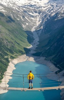 Mountaineers on a suspension bridge, picturesque mountain landscape near the Olpererhuette, view of