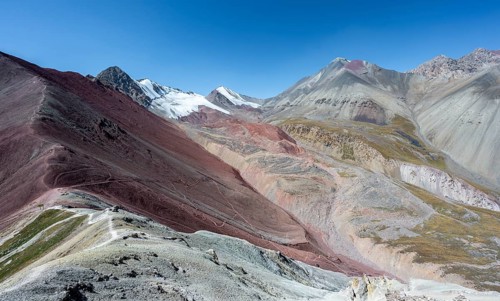 Mountain landscape of glacial moraines, mountains with red and yellow rocks, glaciated mountains in