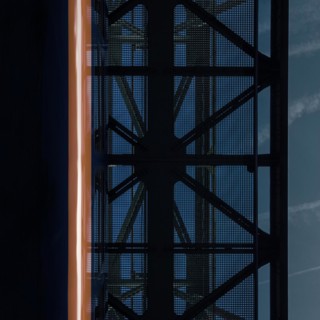 View of a dark, textured ceiling design with a mysterious orange light at the edge, suspension