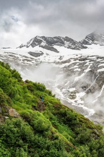 Mountaineers on a hiking trail, in the background glaciated peak Dosso Largo and glacier