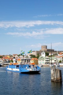 Ferry in the harbour of the archipelago island Marstrandsoe, behind the fortress Carlsten,