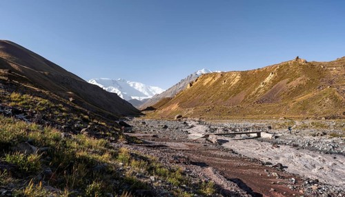 Bridge over the river Achik Tash, Achik Tash valley, behind glaciated and snow-covered mountain