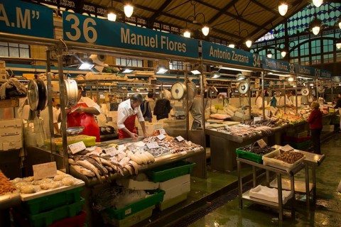 People shopping at fishmonger stalls inside historic covered market building, Jerez de la Frontera,