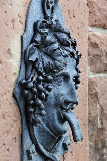 Fountain with Bacchus figure in the vineyards at Dambach-la-Ville, Vosges, Alsace, France, Europe
