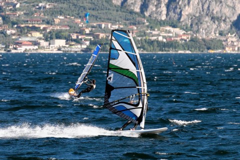 Windsurfers surfing in strong winds on Lake Garda near Malcesine, Veneto, Italy, Europe