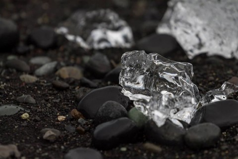 A piece of glacial ice, melting on the black sand beach near Joekulsarlon glacial lake on the