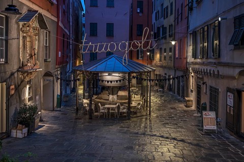 Rerstaurant seats in the evening in a historic public wash house, Piazza Truogoli di Santa Brigida,