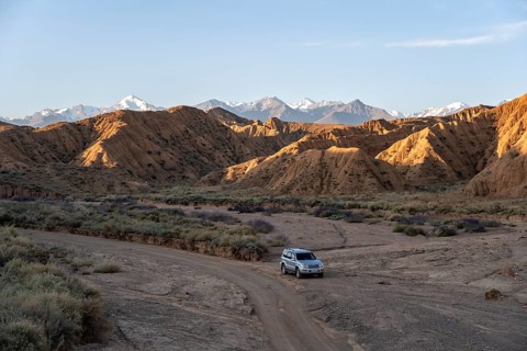 Off-road vehicle on off-road road, eroded hilly landscape, Badlands, Valley of the Forgotten