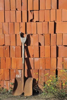 Shovel and pile of stacked red bricks at brickworks, Boom, Belgium, Europe