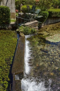 Weir with water mill wheel on a small canal in Goudargues, Departement Gard, Occitanie region,