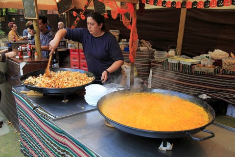 Woman cooking local food in giant pans on a market stall, Algeciras, Spain, Europe