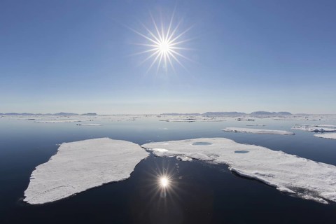 Midnight sun over the Arctic Ocean with drifting ice floes, north of the Arctic Circle at