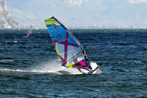 Windsurfers surfing in strong winds on Lake Garda near Malcesine, Veneto, Italy, Europe