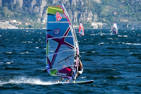 Windsurfers surfing in strong winds on Lake Garda near Malcesine, Veneto, Italy, Europe