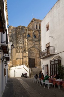 Narrow street cafe and church of Santa Maria de la Asuncion, Arcos de la Frontera, Cadiz province,