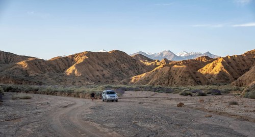 Off-road vehicle on off-road road, eroded hilly landscape, Badlands, Valley of the Forgotten