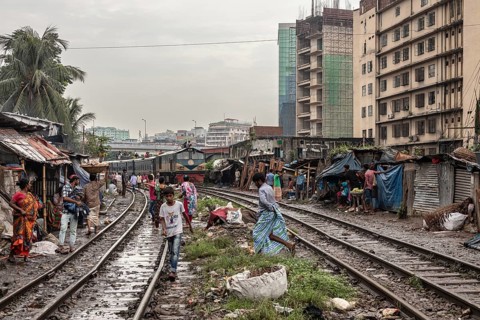 A train passes through an informal settlement built close to a railway line, Tejgaon Slum, Area,