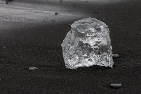 A piece of glacial ice, melting on the black sand beach near Joekulsarlon glacial lake on the