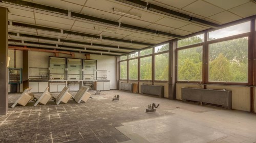 A large empty room with falling ceiling tiles and abandoned lab benches, Biotech, abandoned