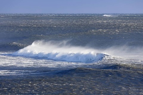 Wave crest at Arctic sea showing airborne spray and spindrift due to high winds