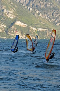Windsurfers surfing in strong winds on Lake Garda near Malcesine, Veneto, Italy, Europe