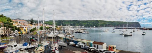 Panoramic view of a busy marina of Horta with boats and surrounded by hilly landscape, Horta, Faial