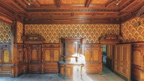 A sumptuously decorated room with wood panelling and antique furniture, Villa Woodstock, Lost