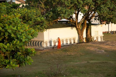 Buddhist monk sweeping temple grounds in the historic town of Galle, Sri Lanka, Asia