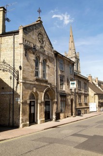 All Saints church spire and Old Fellows Hall, Church Street, Stamford, Lincolnshire, England, UK