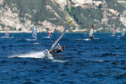 Windsurfers surfing in strong winds on Lake Garda near Malcesine, Veneto, Italy, Europe
