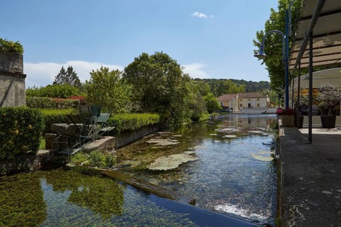 Small canal with weir and mill wheel in Goudargues, Departement Gard, Occitanie region, France,