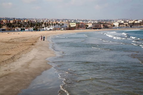 People walking on sandy beach Melilla autonomous city state Spanish territory in north Africa,