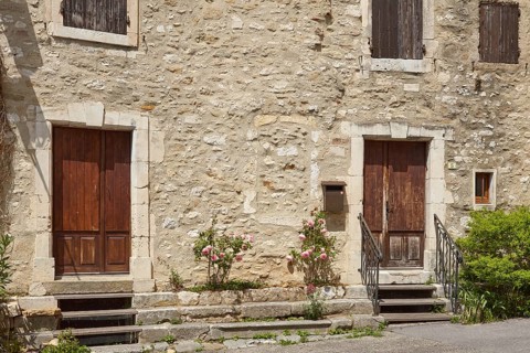 Facades of old houses with doors, windows and shutters in Goudargues, Departement Gard, Occitanie