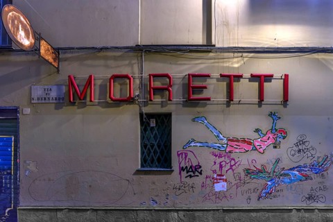 Moretti, lettering of a bar, underneath graffiti on a house wall, historic centre, Genoa, Italy,