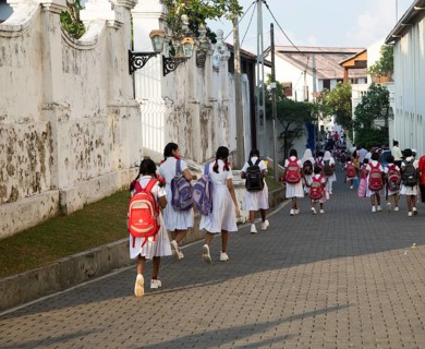 School girls in uniform walking in a street in the historic town of Galle, Sri Lanka, Asia