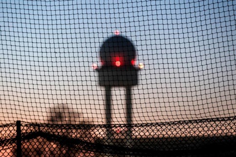 Evening mood at Tempelhofer Feld, view through a fence to the radar tower at the former Tempelhof