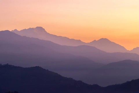 Silhouette of the Himalayan peaks, including Himalchuli and Baudha Himal, backlit by the orange