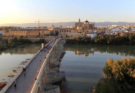 Roman bridge spanning river Rio Guadalquivir with Mezquita cathedral buildings, Cordoba, Spain,
