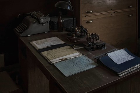 An old office with antique typewriter and desk lamp in the semi-darkness, Dahlhausen railway depot,
