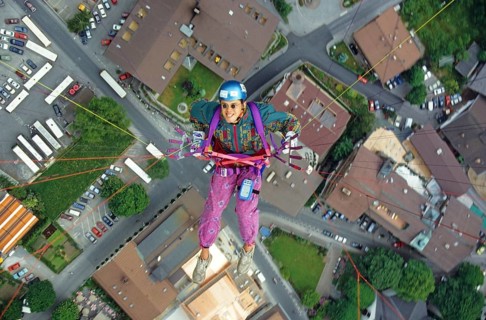 Paragliding pilot with colorful clothes, and small round sunglasses, flying high above Mayrhofen,