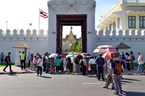 Crowds of tourists push through the entrance gate, Mani Nopparat Gate into the Grand Palace,