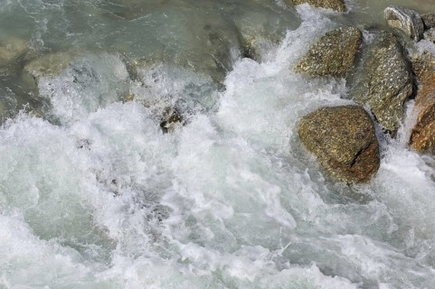Glacial water flowing fast over boulders in alpine mountain stream, Swiss Alps, Switzerland, Europe