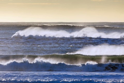 Crests of braking waves at Arctic sea showing airborne spray and spindrift due to high winds
