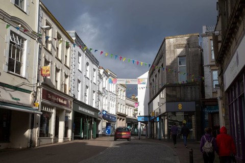Threatening grey rain clouds over town centre street, Falmouth, Cornwall, England, United Kingdom,